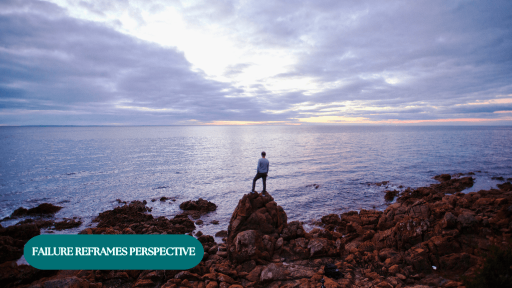 A person standing at the edge of a cliff, looking out at the horizon, representing a changed perspective.
